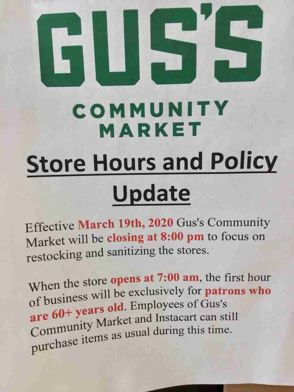 Sign at Gus’s Community Market noting Store Hours and Policy Update effective March 19th, 2020, closing earlier at 8pm for sanitizing, and first hour at 7am exclusively for 60+ years old patrons, and Instacart.