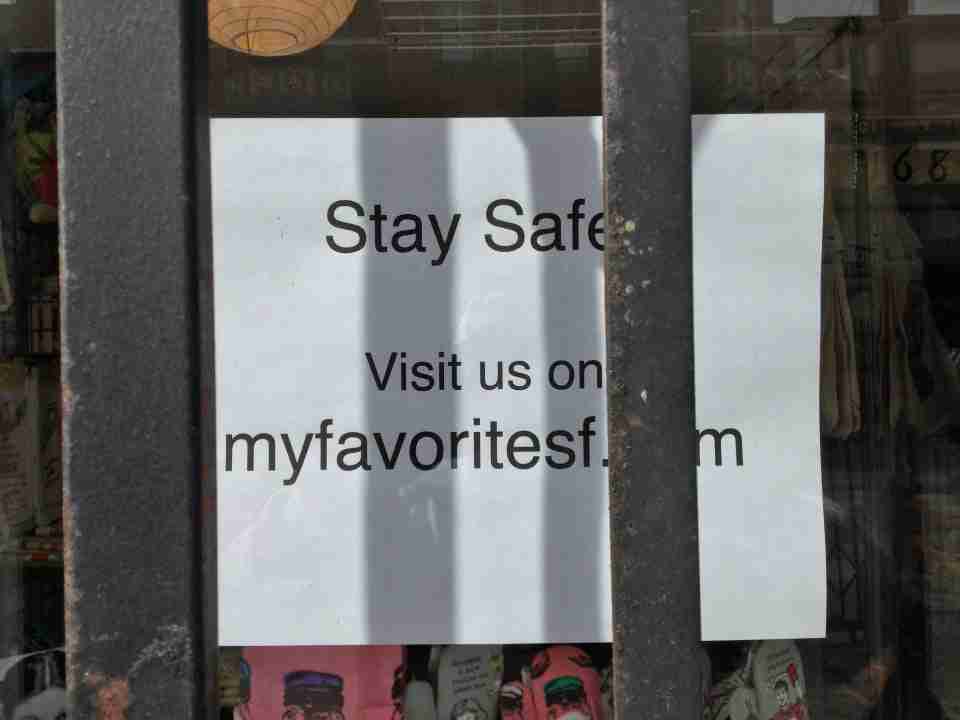 Printed sign saying “Stay Safe / Visit us on myfavoritesf._m” with the “co” hidden behind a metal bar.
