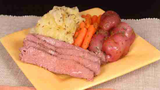 A corned beef and cabbage dinner with potatoes and carrots