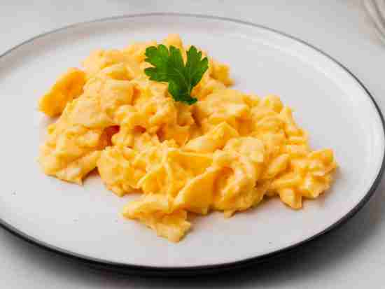 Scrambled eggs, Omelette. Breakfast with pan-fried eggs, cup of