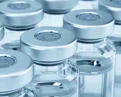 Closeup of glass vial laboratory equipment for dispensing vaccines.